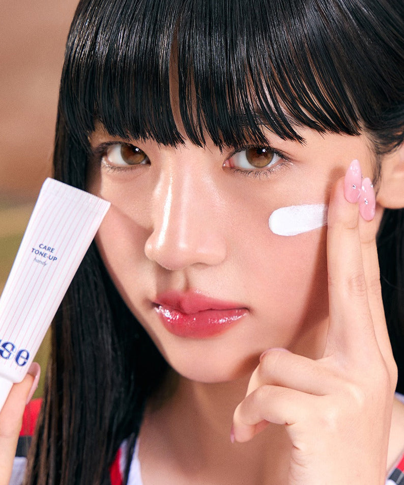 NUSE X Landers Care Tone Up Handy, tube de crème sur une femme au visage, application maquillage, contexte beauté.