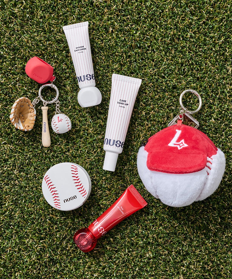 Produits sur gazon incluant le NUSE X Landers Care Tone Up Handy, accessoires de baseball et cosmétiques élégants.