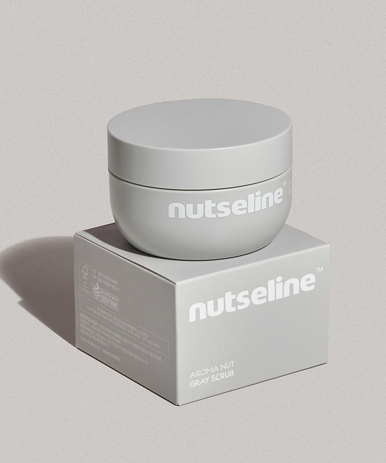 Boîte NUTSELINE Aroma Nut Gray Body Scrub 200g posée sur boîte, emballage gris élégant.