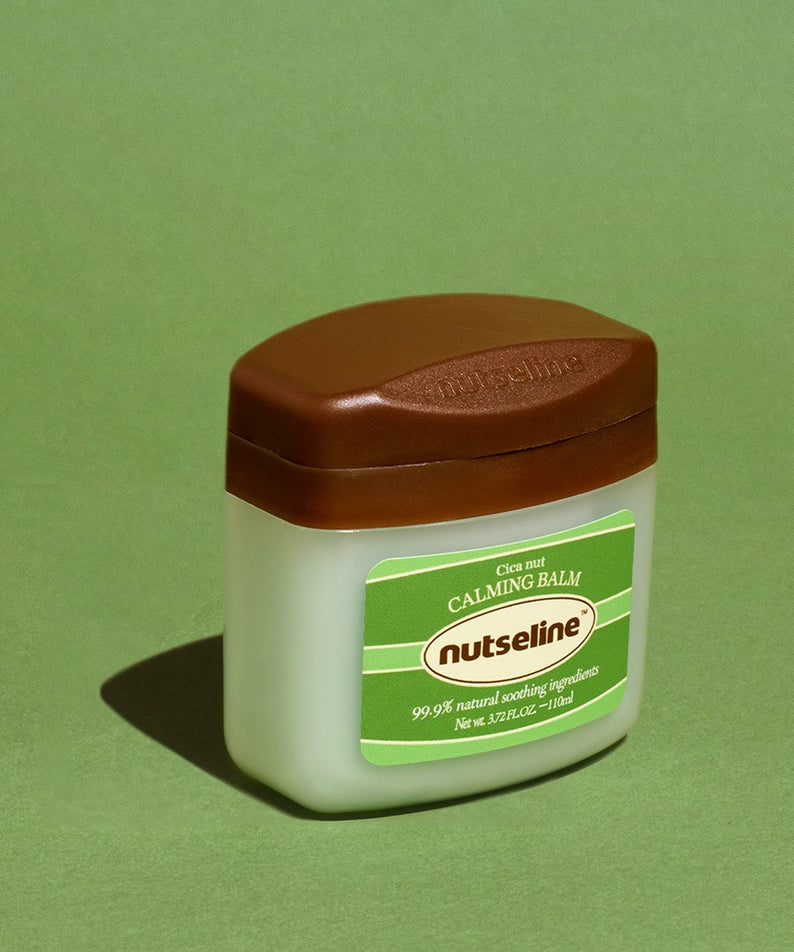 NUTSELINE Cica Nut Calming Balm Season 2 50ml, baume apaisant de la marque sur fond vert, pot blanc et étiquette verte.
