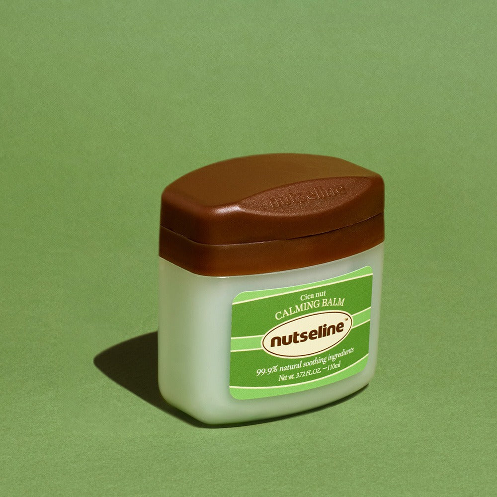 NUTSELINE Cica Nut Calming Balm Season 2 50ml, baume apaisant de la marque sur fond vert, pot blanc et étiquette verte.