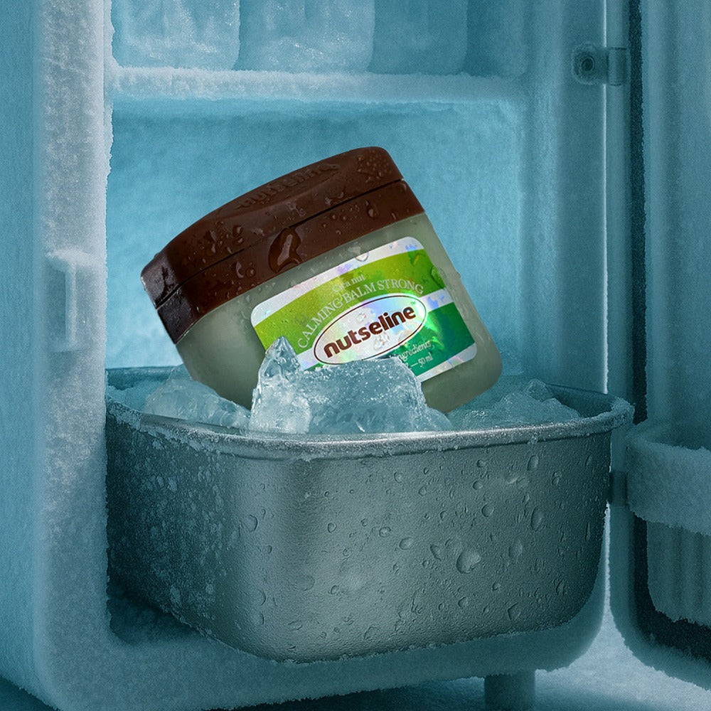 NUTSELINE Cica Nut Calming Balm Strong 50ml de NUTSELINE, baume apaisant sur glace/compartiment froid, contexte visuel bleu.