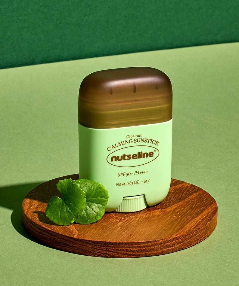 Bâton solaire apaisant NUTSELINE Cica Nut Calming Sun Stick 18g sur fond vert, protection SPF en format pratique.