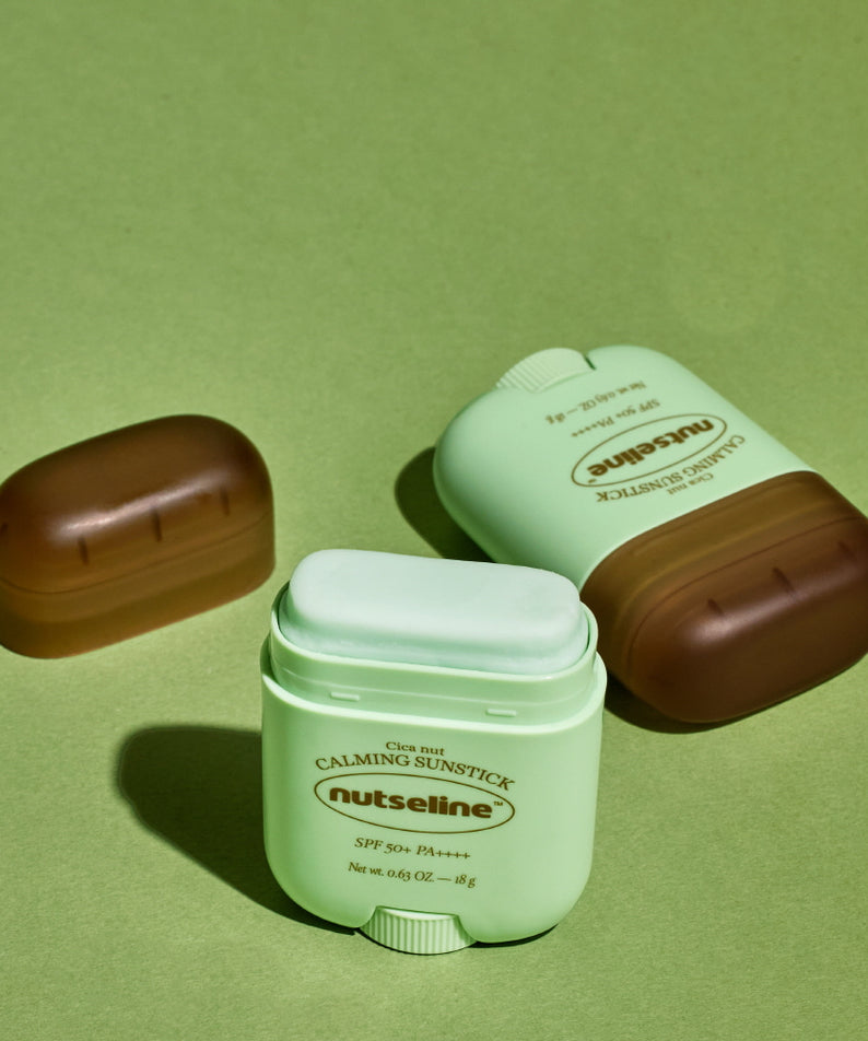 NUTSELINE Cica Nut Calming Sun Stick 18g, protection solaire apaisante sur fond vert, stick solaire format compact.