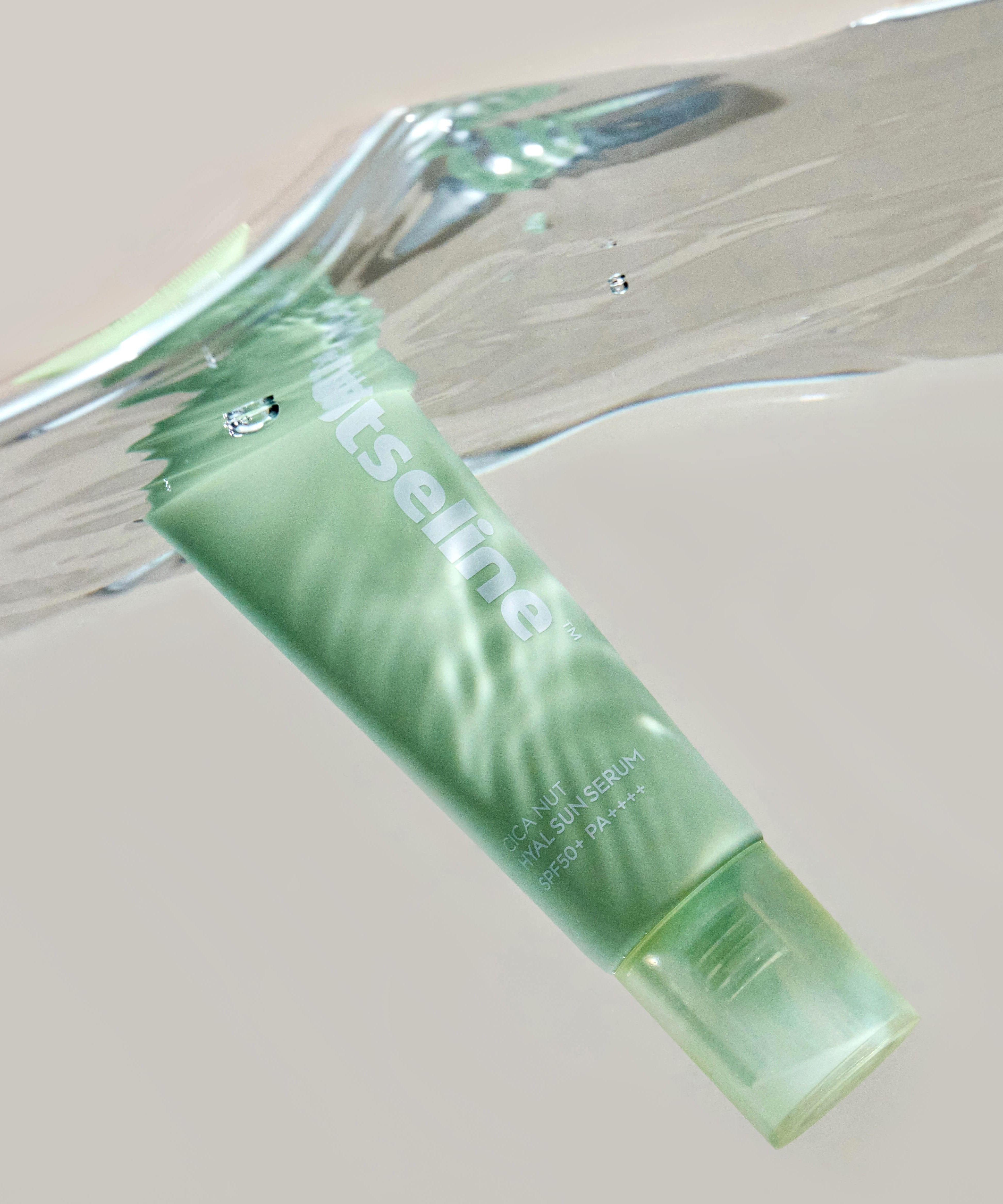 NUTSELINE Cica Nut Hyal Sun Serum 50ml, tube vert posé sur fond neutre, mise en scène cosmétique.
