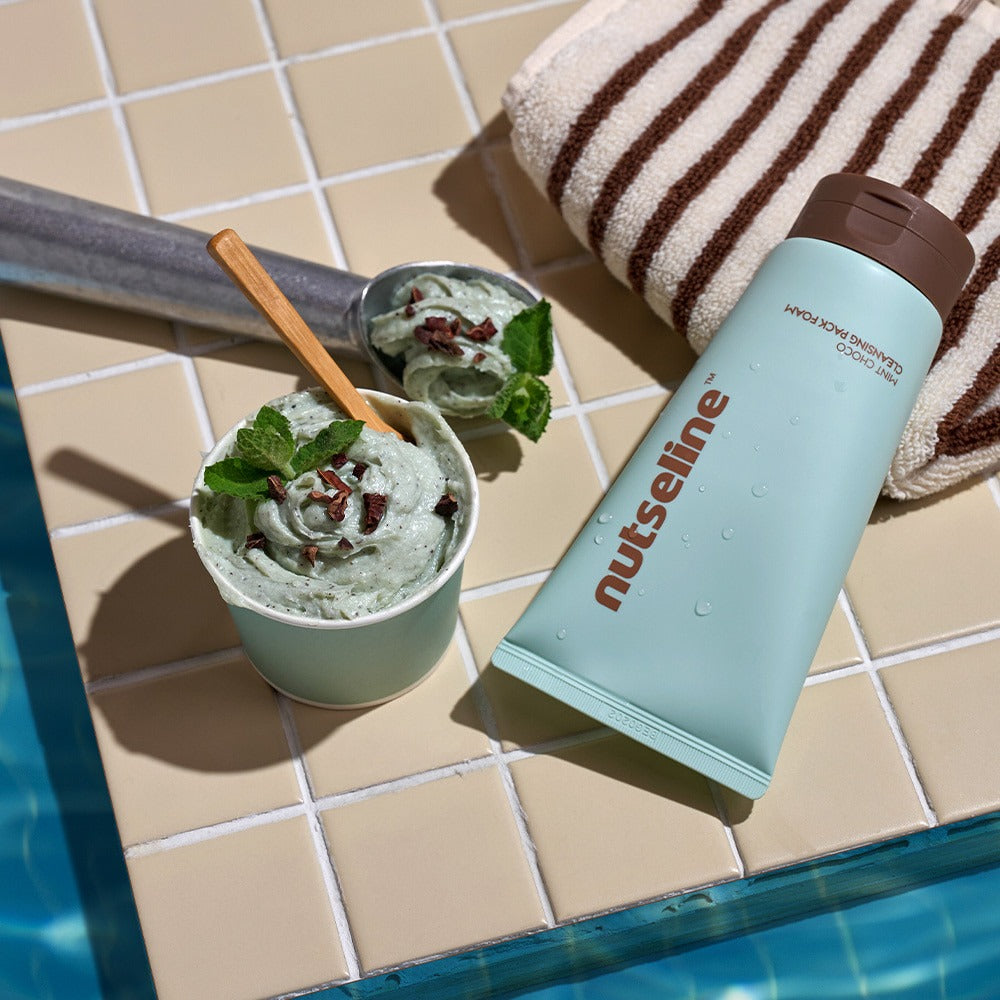 NUTSELINE Mint Chocolate Cleansing Pack Foam 130g, marque sur tube menthe-chocolat près d’une mousse verte en salle de bain