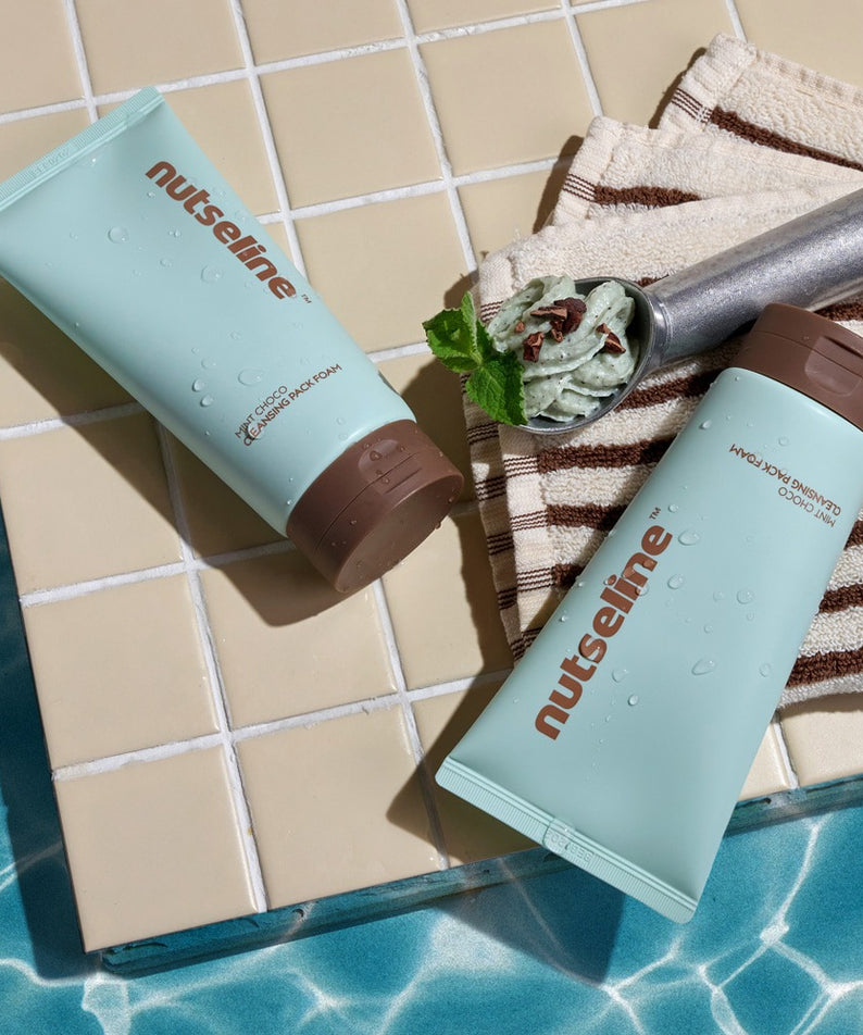 NUTSELINE Mint Chocolate Cleansing Pack Foam 130g de la marque NUTSELINE, sur carrelage et serviettes, ambiance salle de bain.