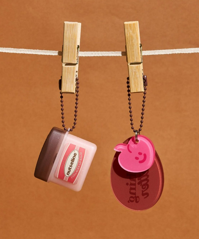 NUTSELINE Super Nut Collagen Keyring Lip Balm 11ml, baume à lèvres en porte-clés sur fond beige, marque NUTSELINE, visuel produit.