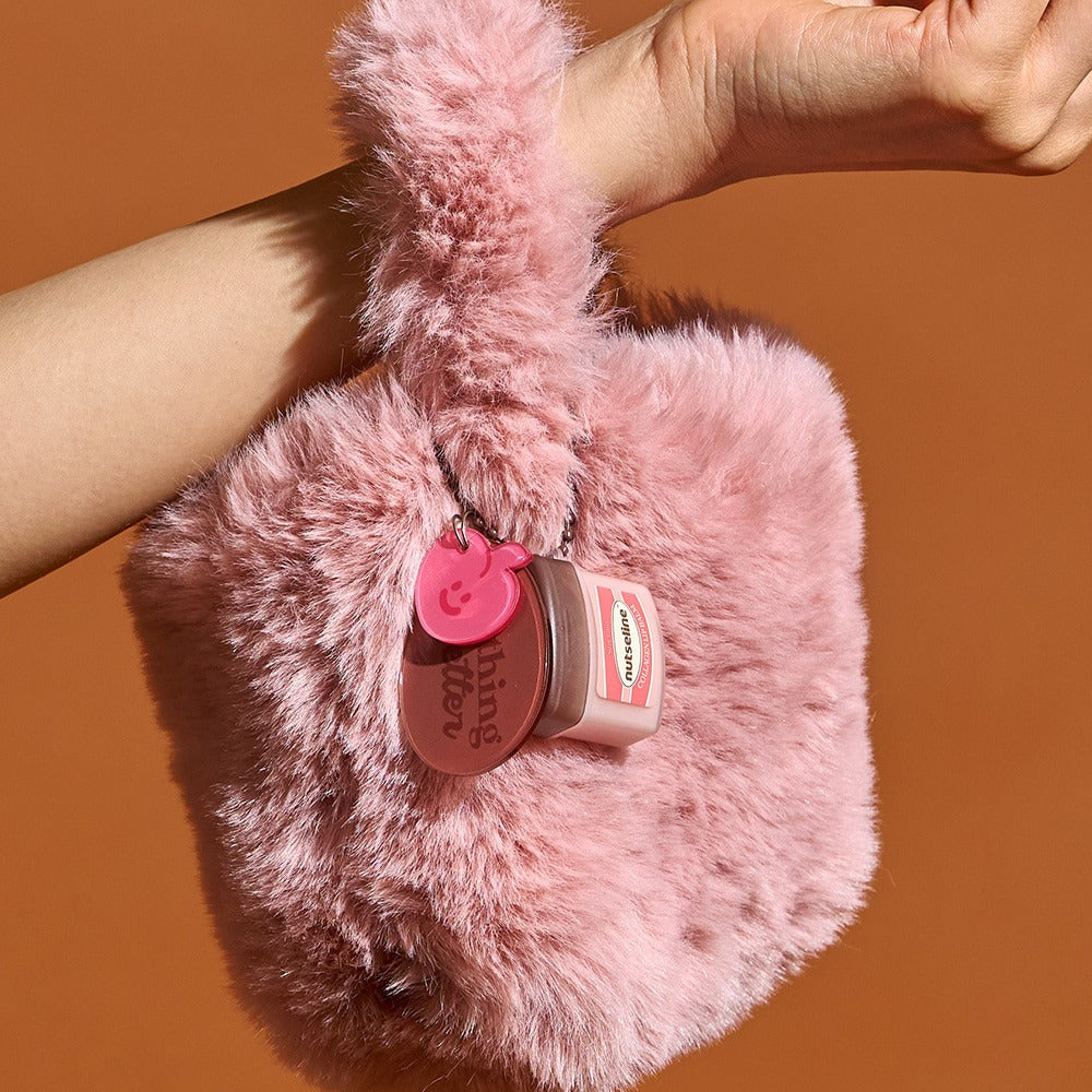 Décris l'image en français en mentionnant le produit, la marque et le contexte visuel: NUTSELINE Super Nut Collagen Keyring Lip Balm 11ml