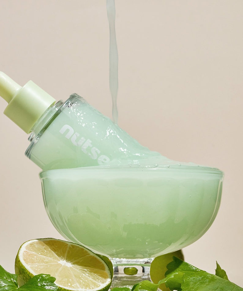 NUTSELINE Cica Nut Hyal Ampoule 90ml dans un bol avec citron vert et feuilles vertes, hydratation intense.