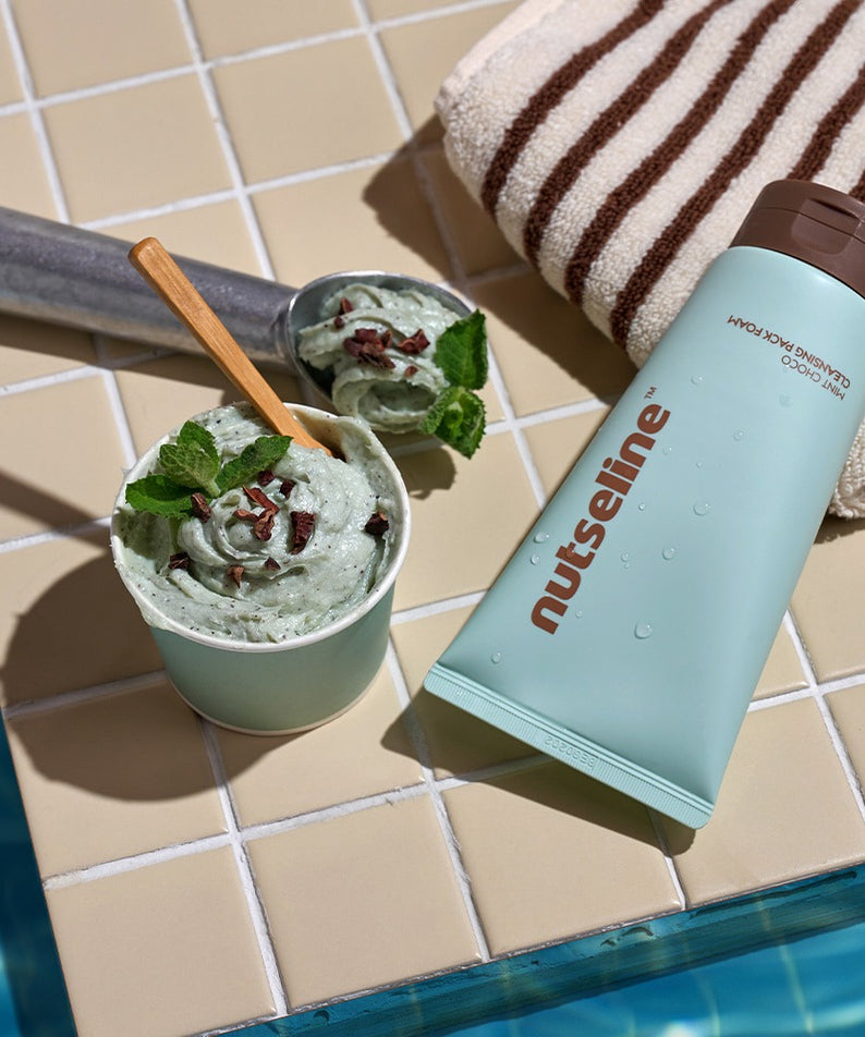 NUTSELINE Mint Chocolate Cleansing Pack Foam 130g posé à côté de gouttes de chocolat à la menthe, spa esthétique.
