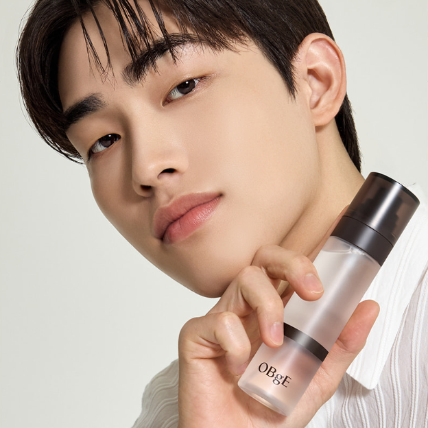 OBGE All-in-one Cool Fixing Mist 100ml, brume fraîche OBGE tenue par un jeune homme, fond clair, photo produit