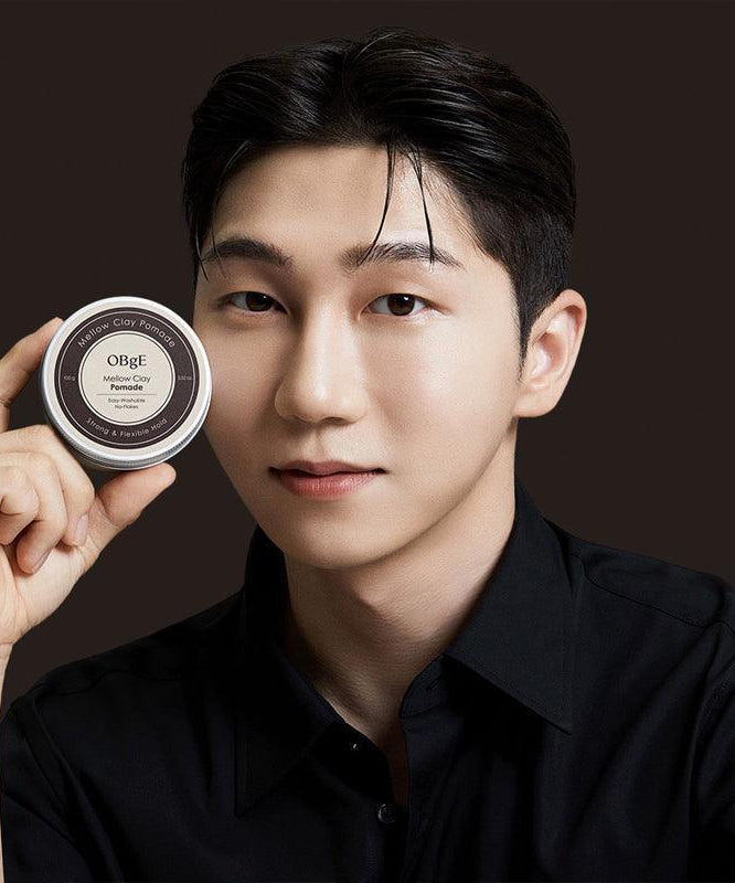 OBGE Mellow Clay Pomade 100g : pot de cire pour cheveux OBGE, homme avec look coiffé sur fond sombre.