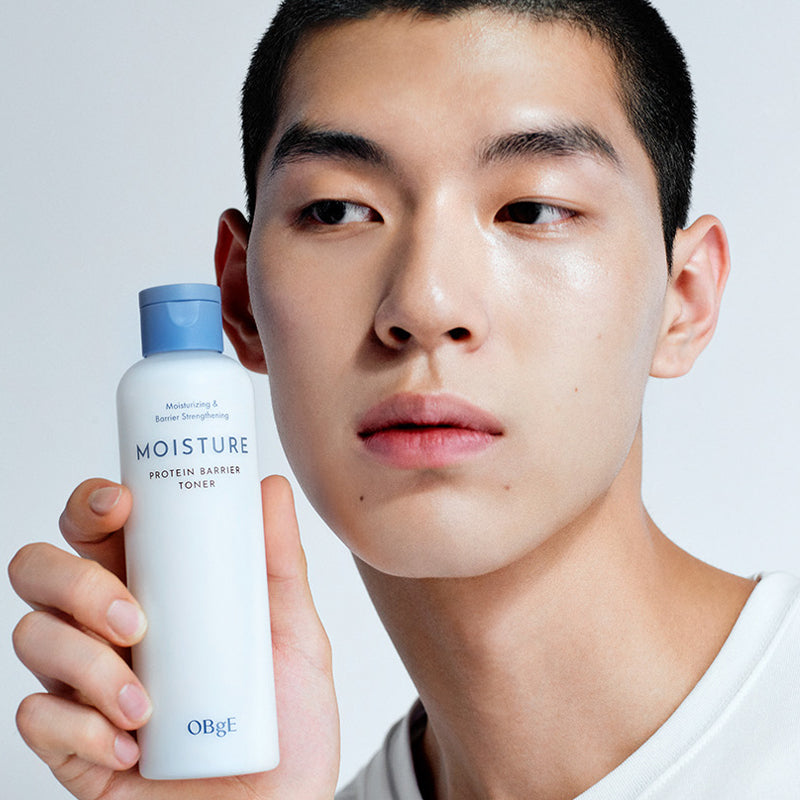 OBGE Moisture Protein Barrier Toner 200ml, flacon bleu tenu par un homme, peau hydratée, fond studio clair.