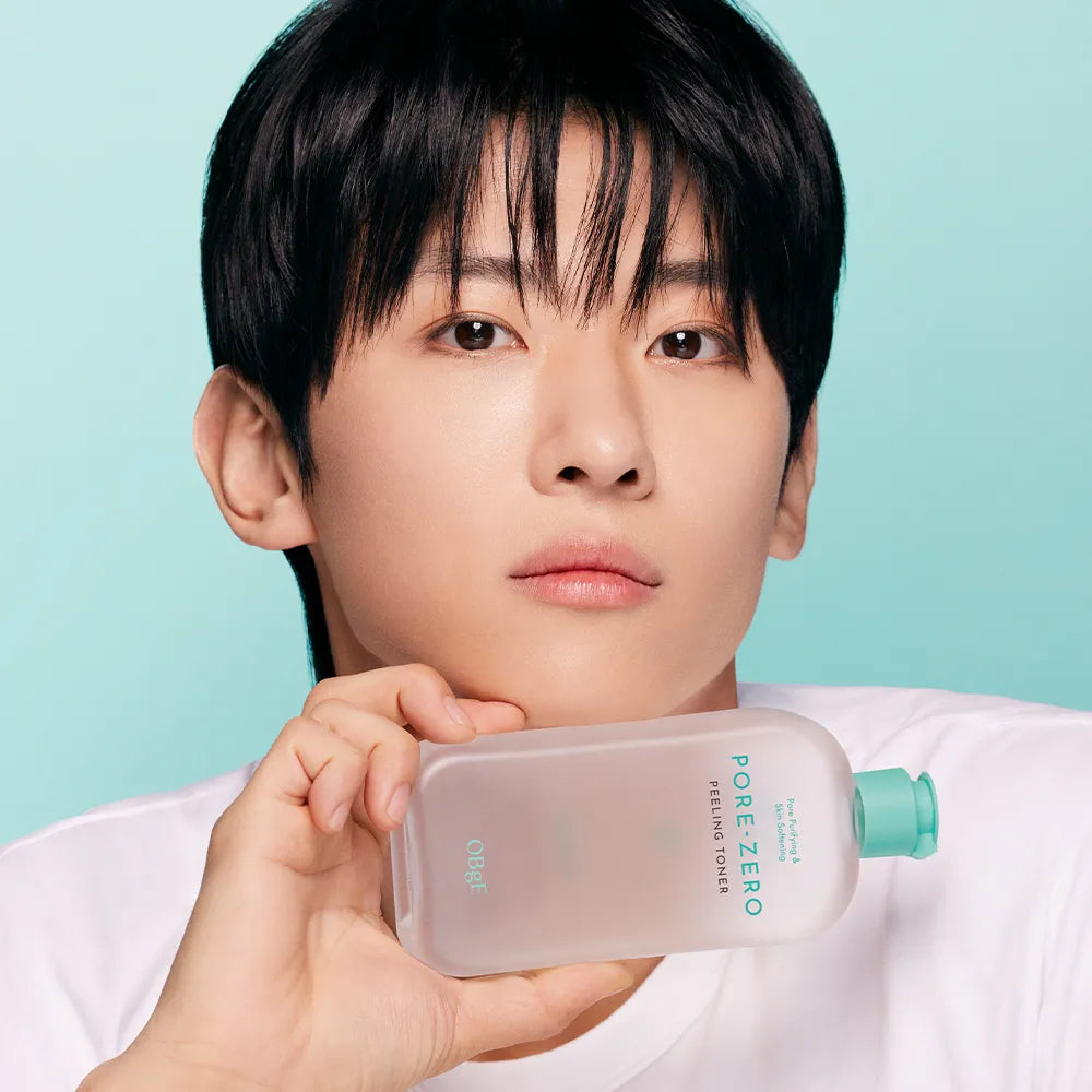OBGE Pore Zero Peeling Toner 310ml de la marque OBGE, flacon tenu par un homme sur fond bleu.