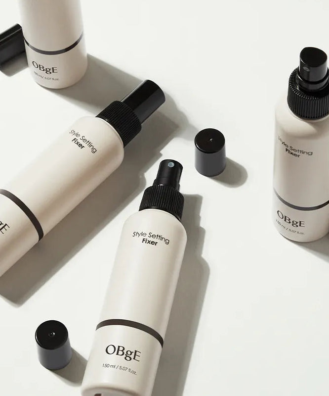 Décris l’image en français : OBGE Style Setting Fixer 150ml, bouteilles de marque OBGE sur fond clair, style capillaire.