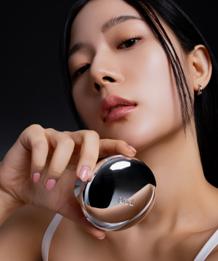Femme tenant le OIAD Pore Perfecting Mirror Moon Cushion, produit cosmétique innovant pour peau parfaite.
