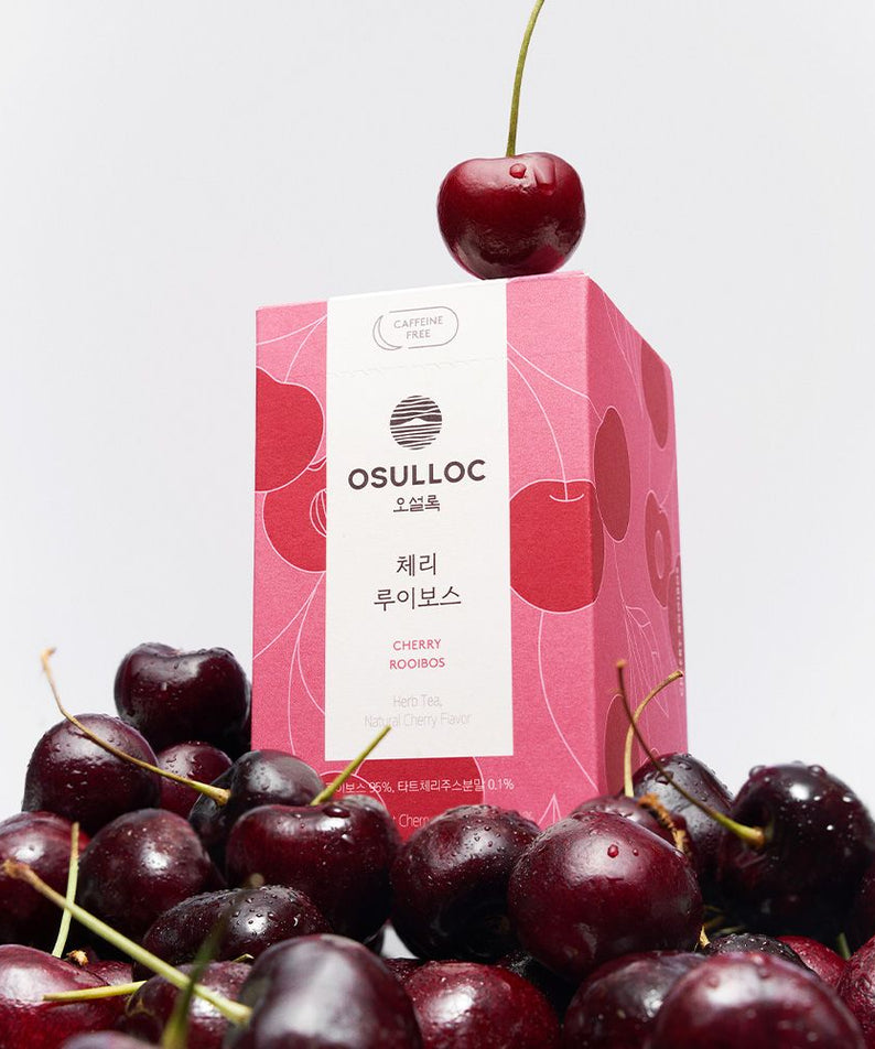 OSULLOC [Caffeine-Free] Cherry Rooibos : sachet OSULLOC et cerises fraîches sur fond clair, ambiance naturelle.