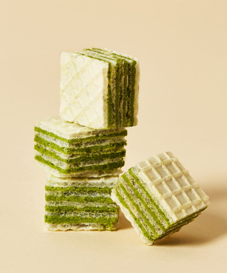 Décris l'image en français: OSULLOC Green Tea Wafers 100g, gaufettes au thé vert de la marque OSULLOC, sur fond clair.