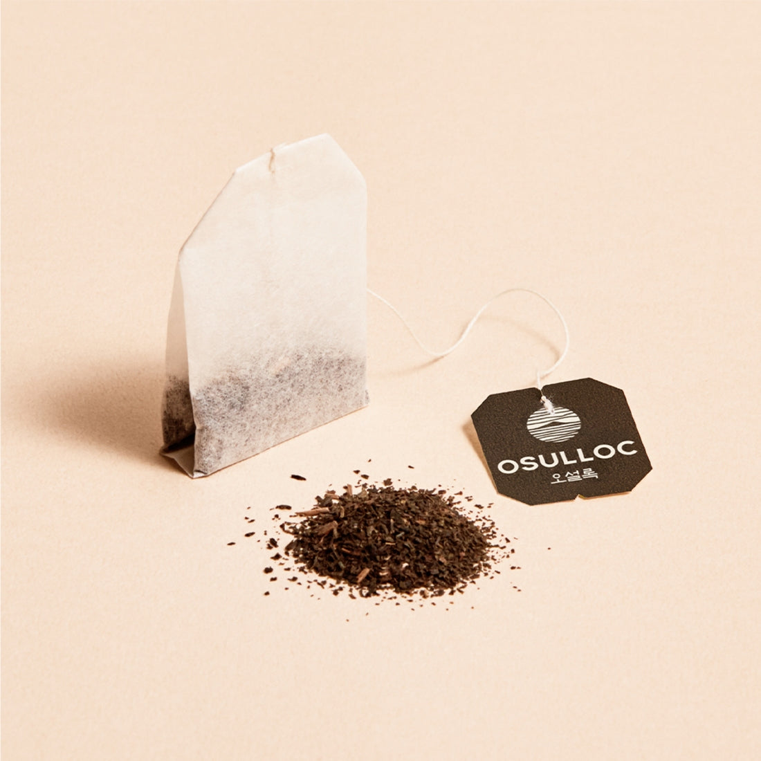 Décris l'image : OSULLOC Jeju Volcanic Oolong Tea 20 P, sachets étiquetés et feuilles de thé sur fond clair.