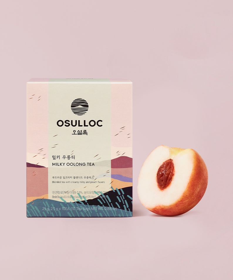 OSULLOC Milky Oolong Tea 10 p, boîte et fruit de pêcher sur fond rose pastel, ambiance photo produit