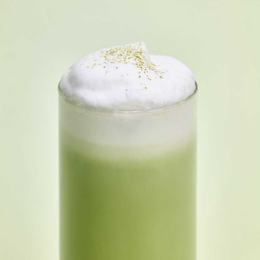 OSULLOC Signature Milk Tea Collection : boisson au lait matcha verte avec mousse blanche, marque OSULLOC, fond vert pastel.