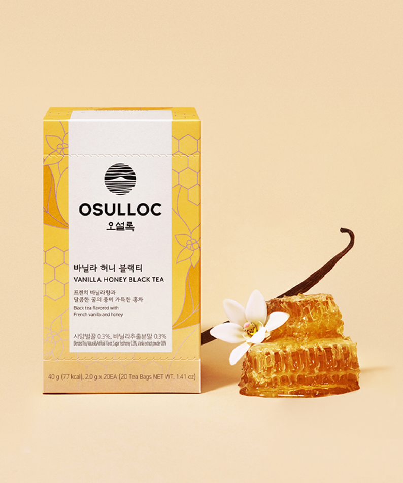 OSULLOC Vanilla Honey Black Tea 20 P, boîte et miel doré sur fond beige avec fleur vanille, image produit en studio.