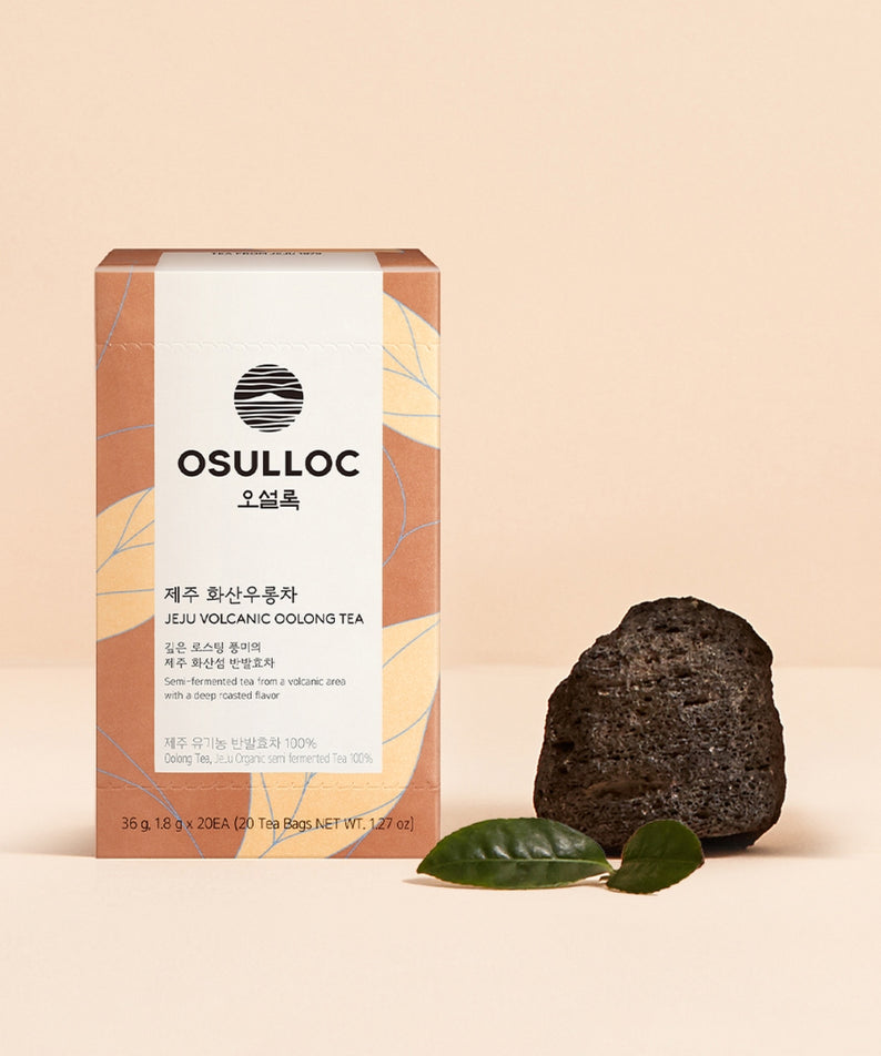 Boîte de OSULLOC Jeju Volcanic Oolong Tea 20 P avec fond de roche volcanique et feuilles vertes.