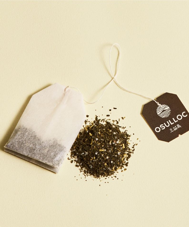 Sachet de thé OSULLOC Canola & Apricot Tea 20 P avec feuilles de thé et étiquette, mis en valeur sur une surface beige.