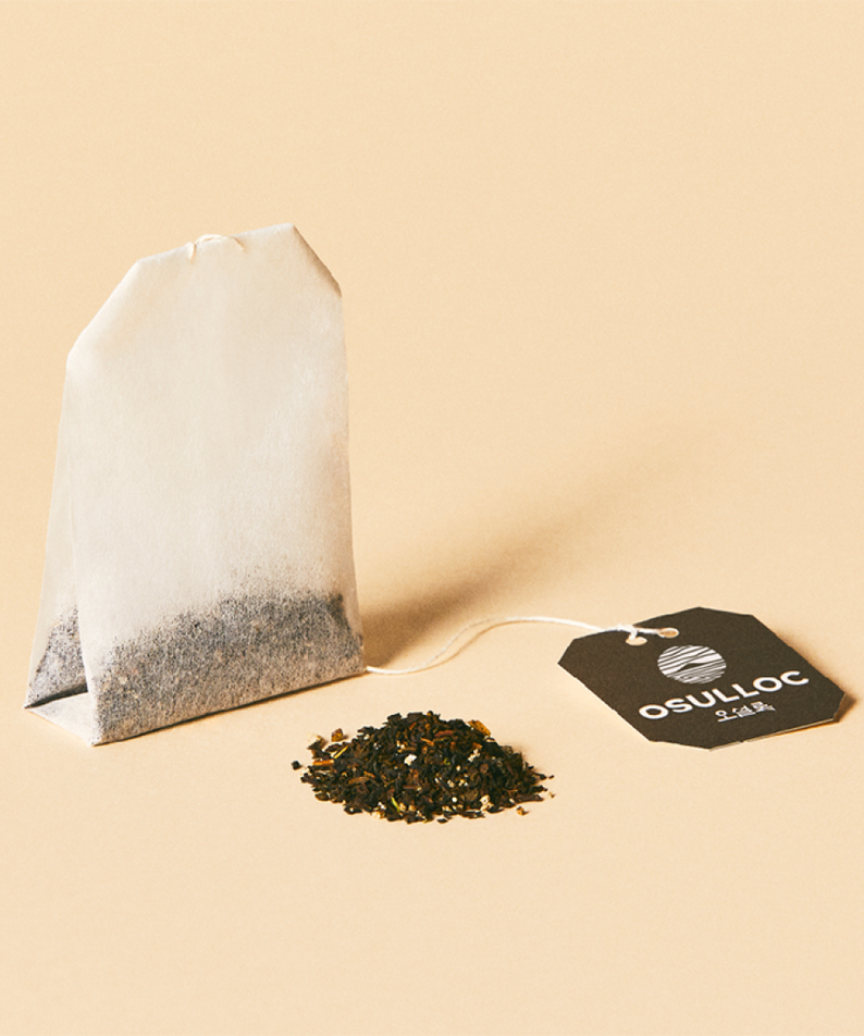 Sachet de thé OSULLOC Vanilla Honey Black Tea 20 P avec étiquette marque, posé sur fond beige avec feuilles de thé."}