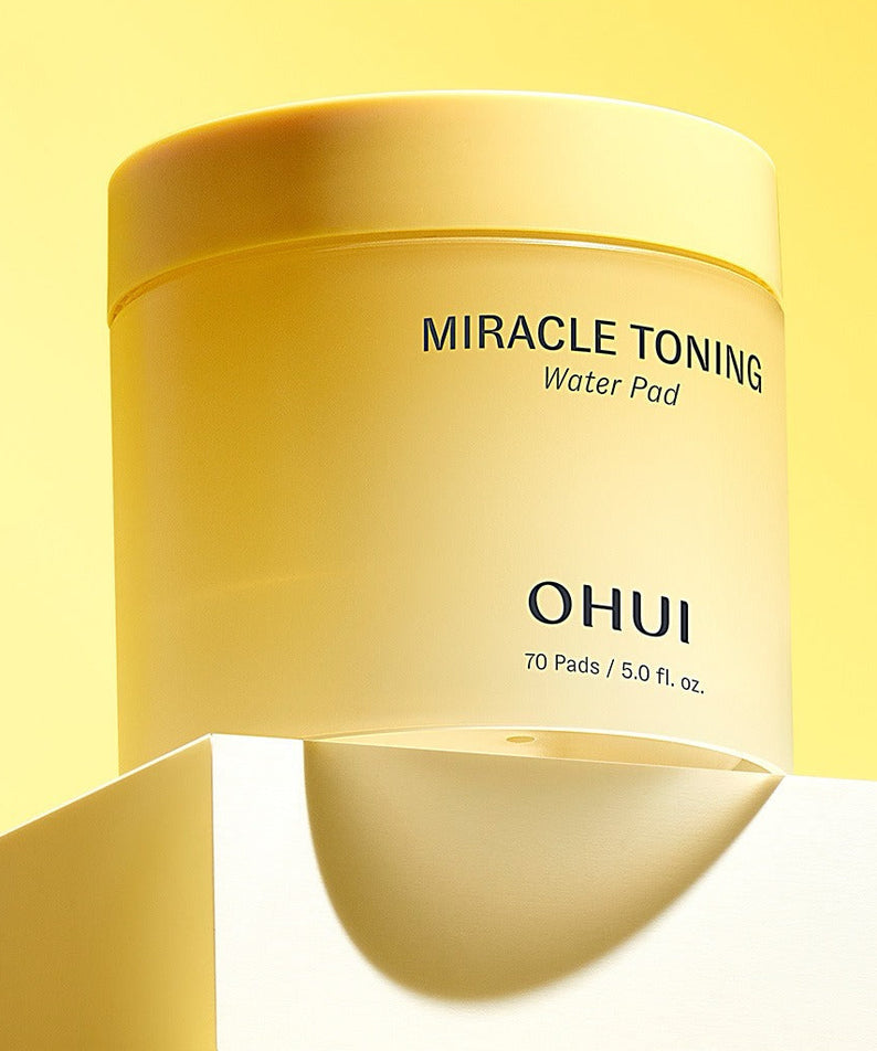 Produit de beauté OHUI Miracle Toning Water Pads 70 sheets en lumière jaune, présentant la boîte de 70 tampons de soin.