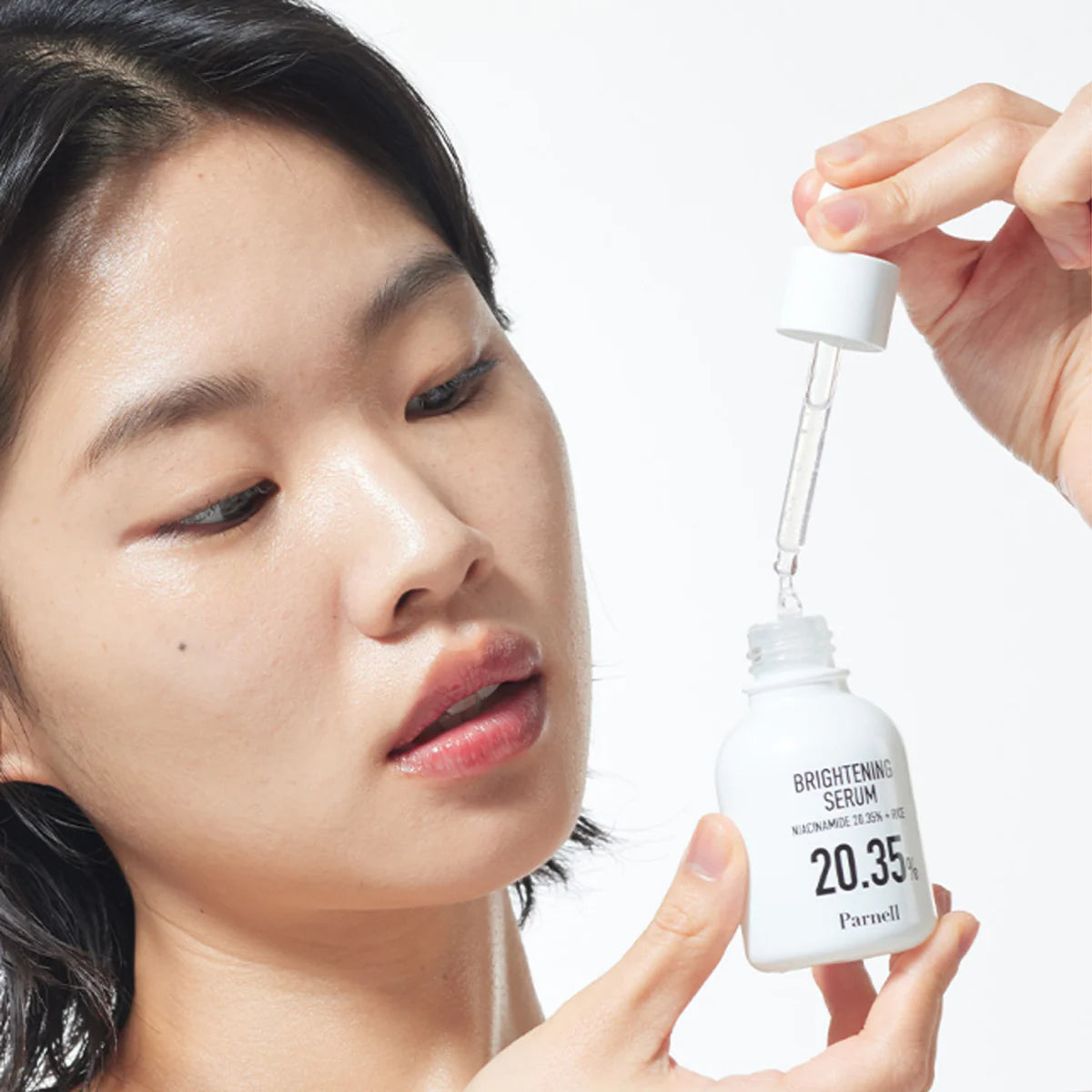 PARNELL  Niacinamide 20.35 Rice Brightening Serum 30ml, sérum appliqué sur visage, flacon et texture sur fond clair