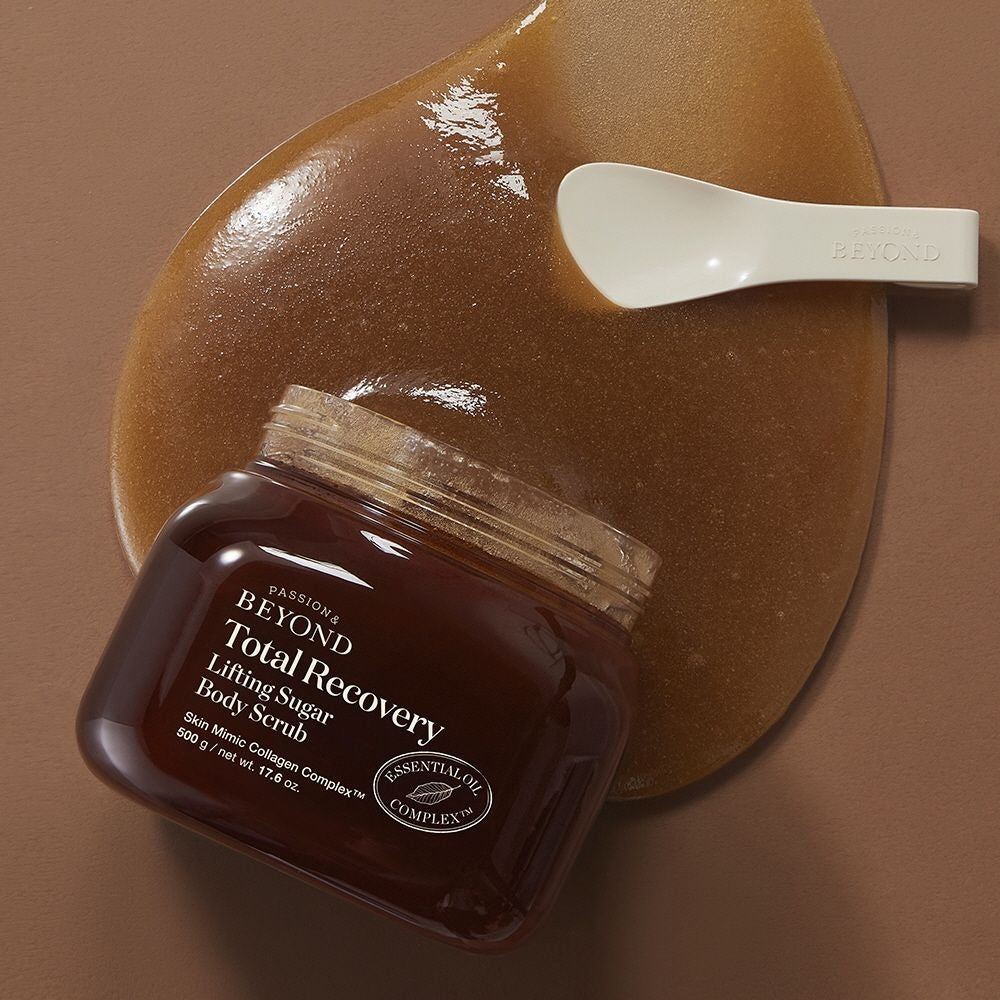 PASSION & BEYOND Total Recovery Lifting Body Scrub 500g de PASSION&BEYOND, pot brun sur fond beige, spatule blanche