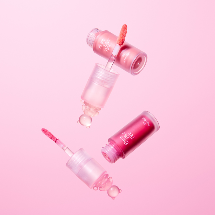 PASSION CAT Bere Blur Tint de la marque Passion Cat, flacons de blur tint roses sur fond rose, gouttes et texture