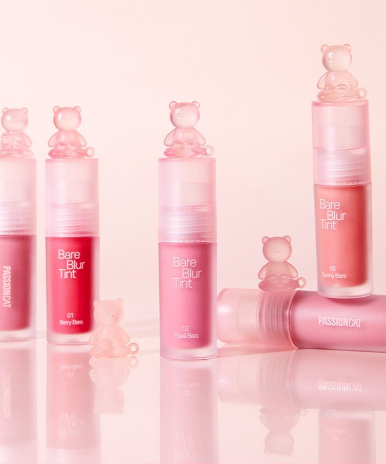 PASSION CAT Bere Blur Tint en plusieurs teintes, maquillage élégant avec des figurines d'ours, atmosphère douce en arrière-plan rose.