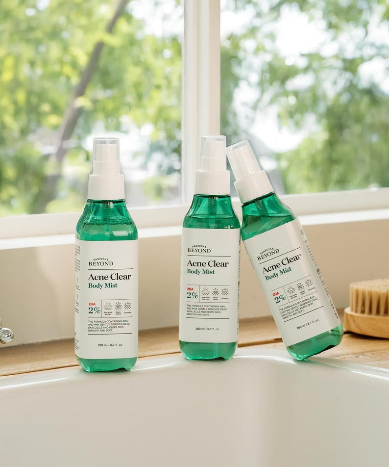 Trois flacons de PASSON&BEYOND Acne Clear Body Mist 200ml sur une fenêtre ensoleillée, solution anti-acné.