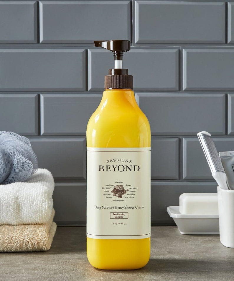 PASSON & BEYOND Deep Moisture Honey Shower 1L : bouteille miel sur planche avec serviettes, salle de bain, arrière-plan briques