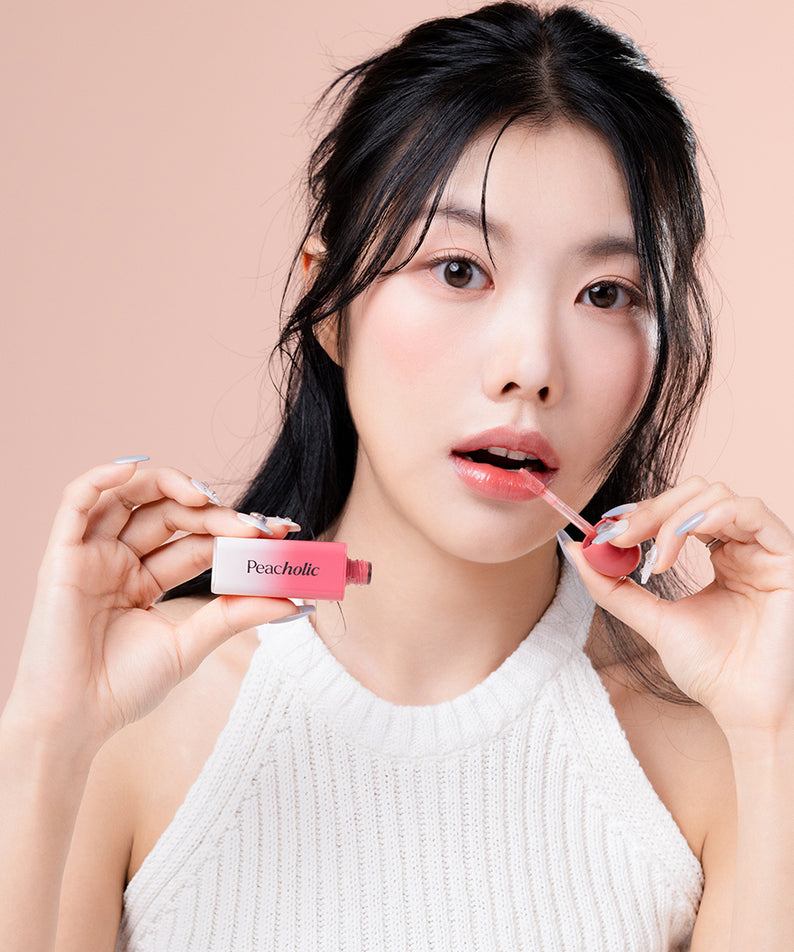 PEACHOLIC Water Glow Lip Tint de PeachAholic, maquillage lèvres sur modèle au fond rose, gros plan.