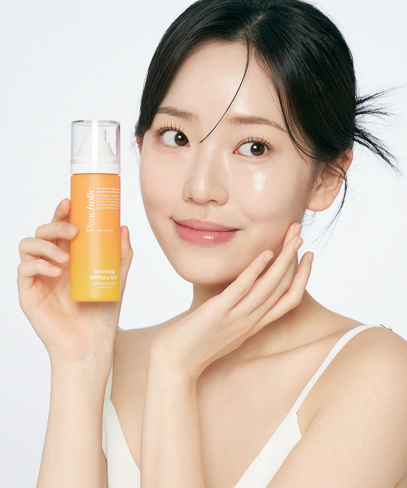 PEACHOLIC  Whitening Ampoule Mist 100ml : femme tenant le flacon sur fond clair, marque PEACHOLIC en évidence.