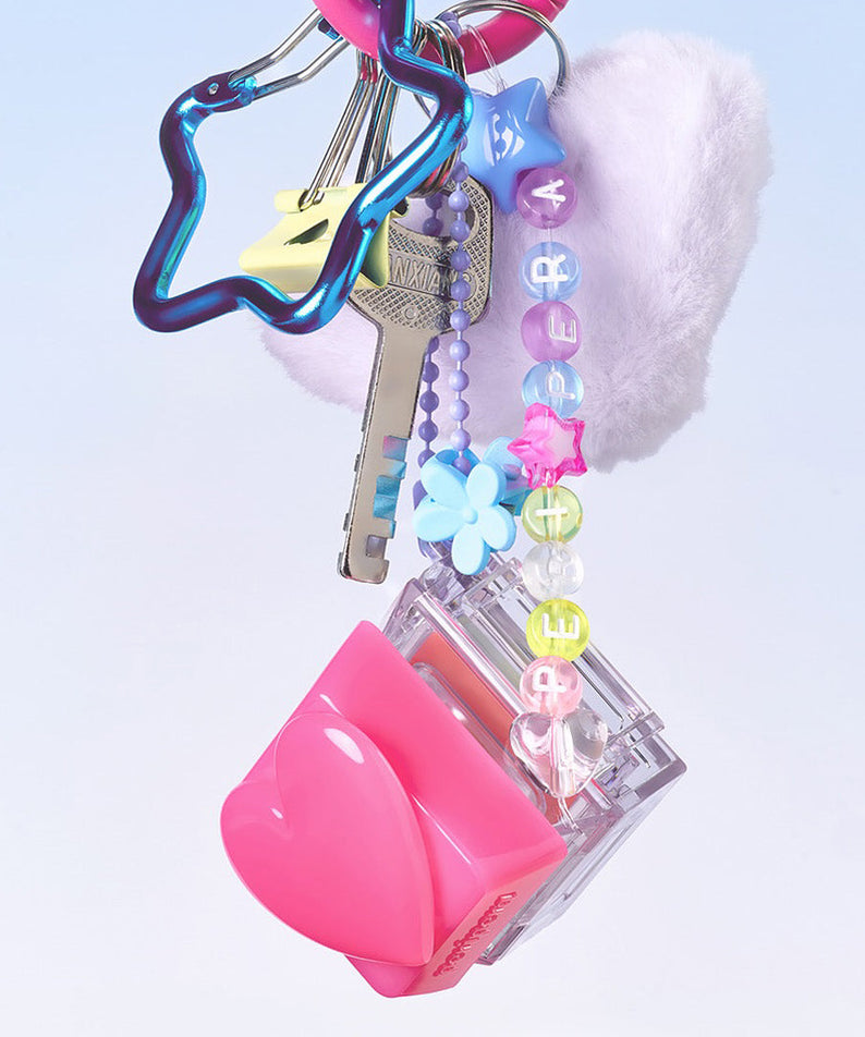 PERIPERA Talk Blush Keycap, sur porte-clés décoratif, style pop, fond clair pastel, accessoires cosmétiques.