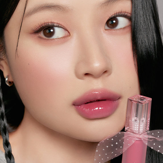 PERIPERA Water Bare Tint : lèvres rosées et flacon rose en gros plan, maquillage naturel, arrière-plan sombre