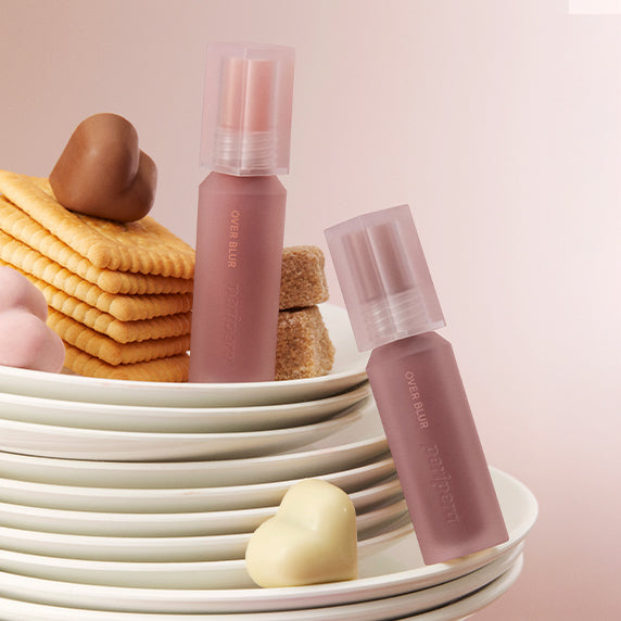 PERIPERA Over Blur Tint de la marque PERIPERA, maquillage lèvres, sur fond crème et biscuits, ambiance pastel.