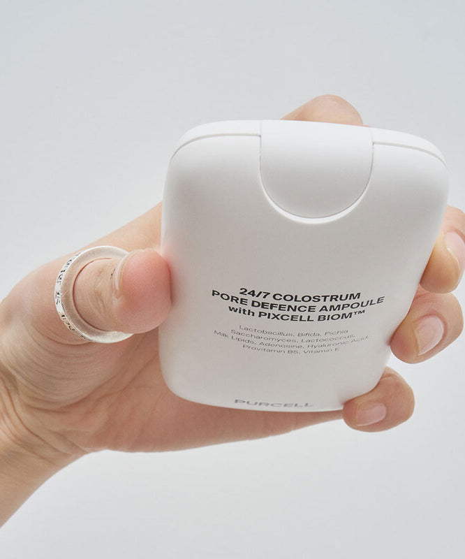 PURCELL 24/7 Colostrum Pore Defense Ampoule 55mL de la marque PURCELL, main tenant l’ampoule sur fond clair