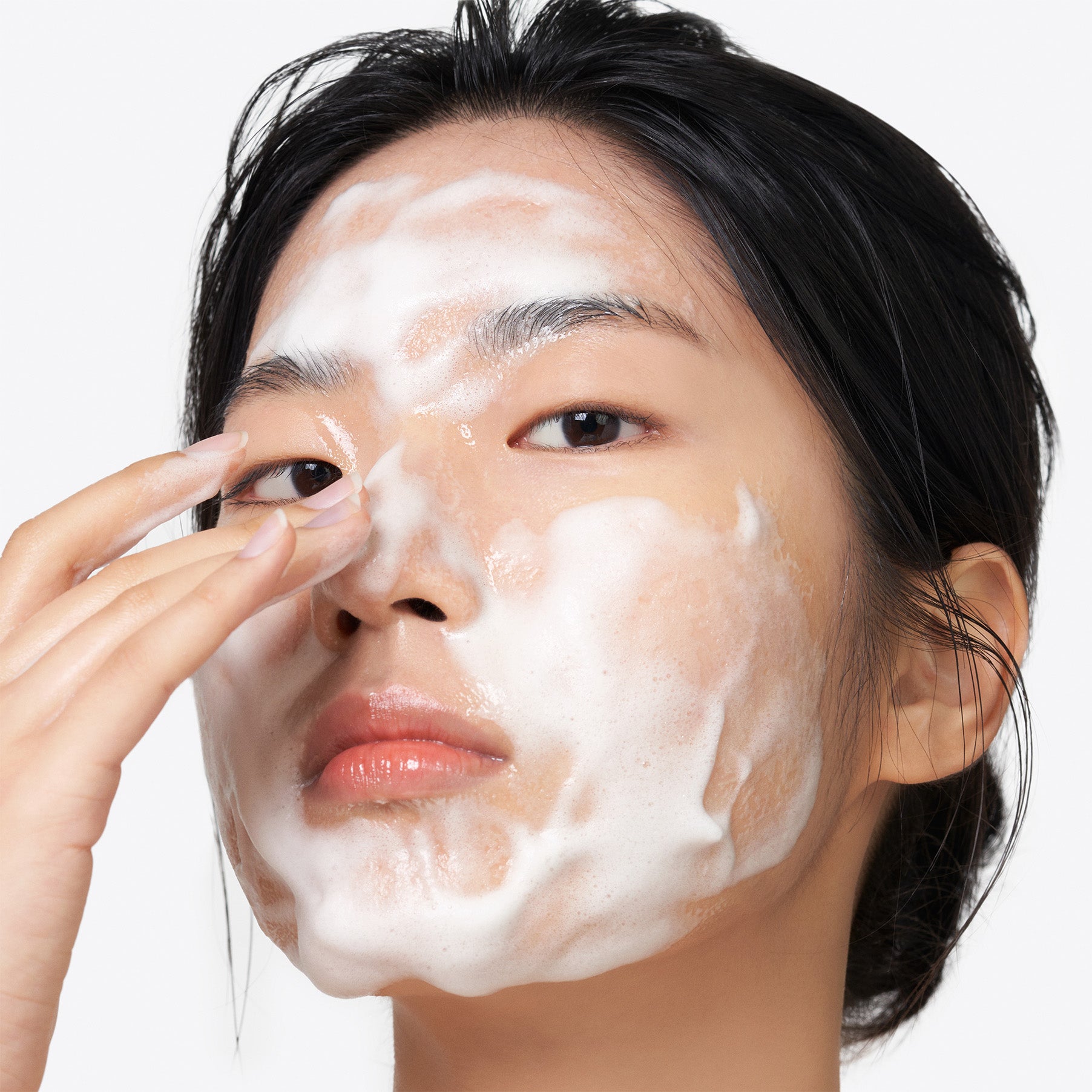 Personne appliquant la mousse du PURITO Clear Code Superfruit Cleanser 150ml, nettoyant visage PURITO sur peau.