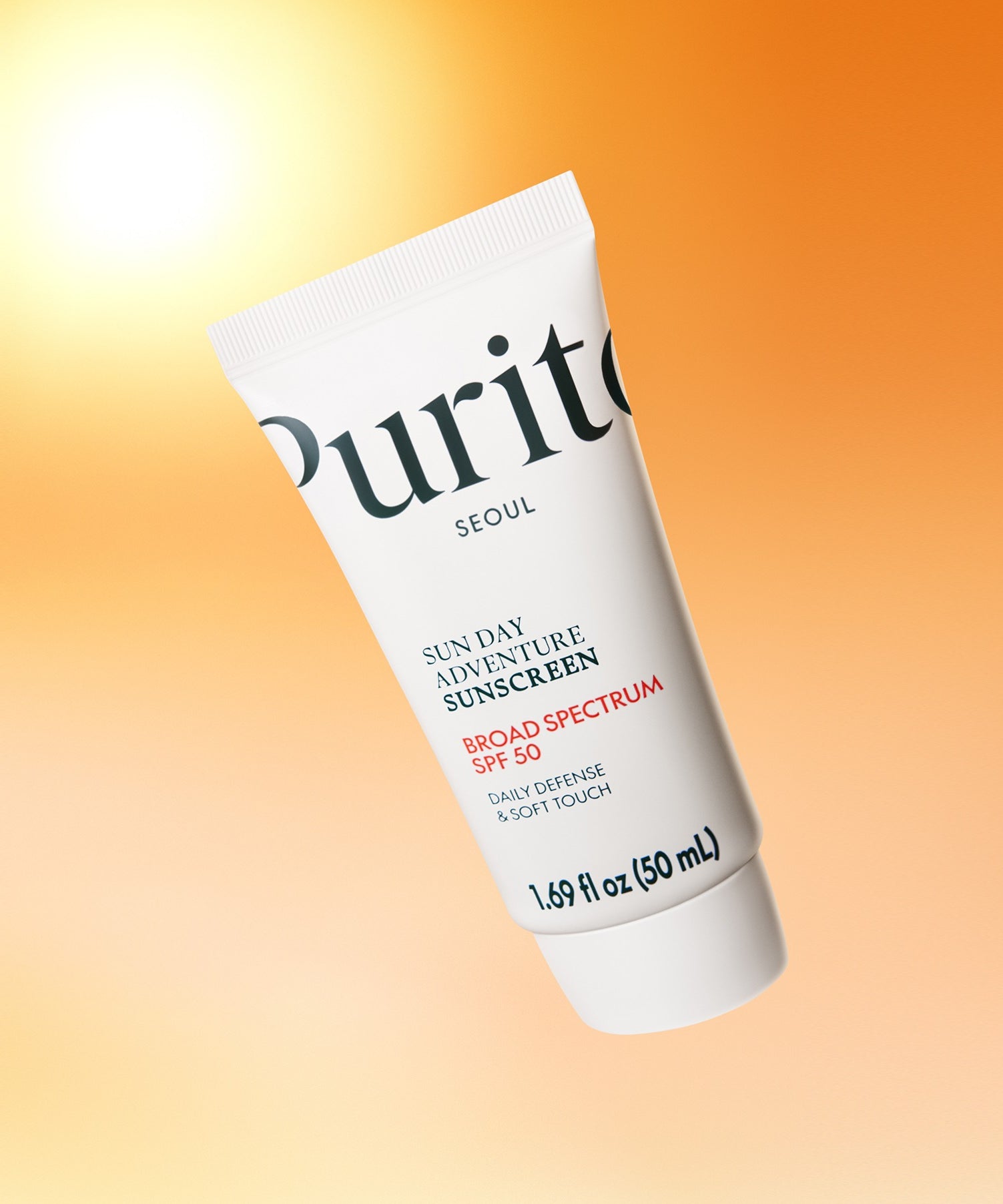 Décrivez l’image : PURITO Sunday Adventure Sunscreen SPF50 50ml, tube PURITO sur fond orange ensoleillé.