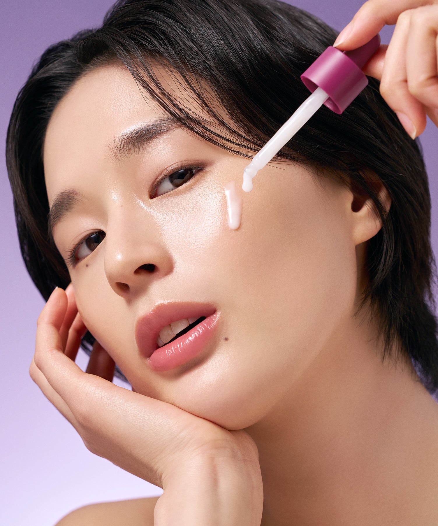 PURITO Timeless Bloom Bakuchiol Serum 30ml de Purito : une femme applique le sérum au compte-gouttes sur le visage, fond violet.