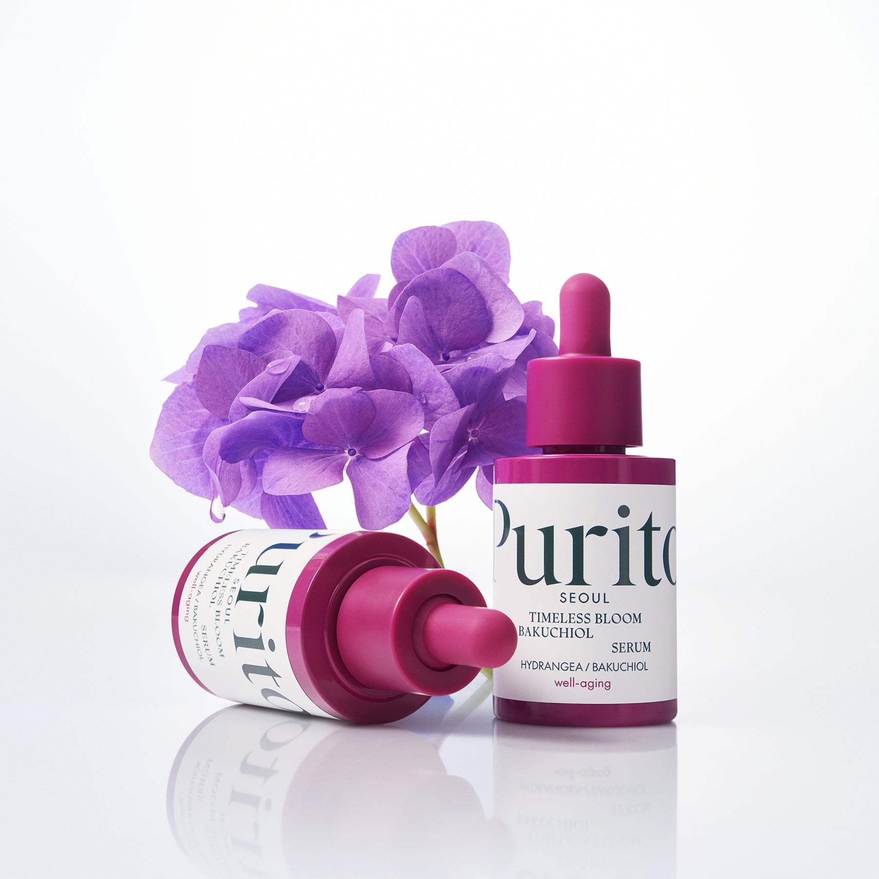 PURITO Timeless Bloom Bakuchiol Serum 30ml de Purito sur fond blanc avec fleurs violettes et sérum