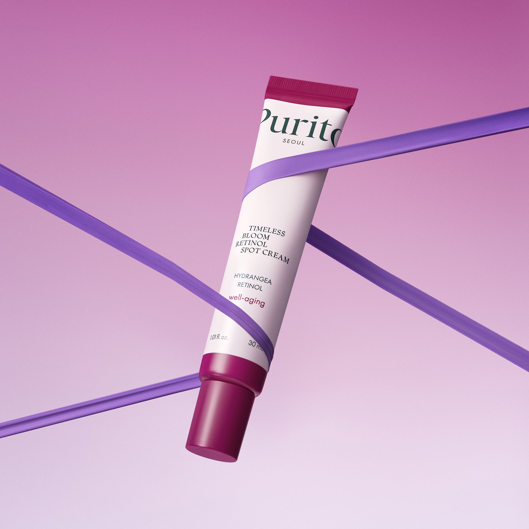 PURITO Timeless Bloom Retinol Spot Cream 30ml de Purito, tube cosmétique sur fond violet, posé sur des diagonales.