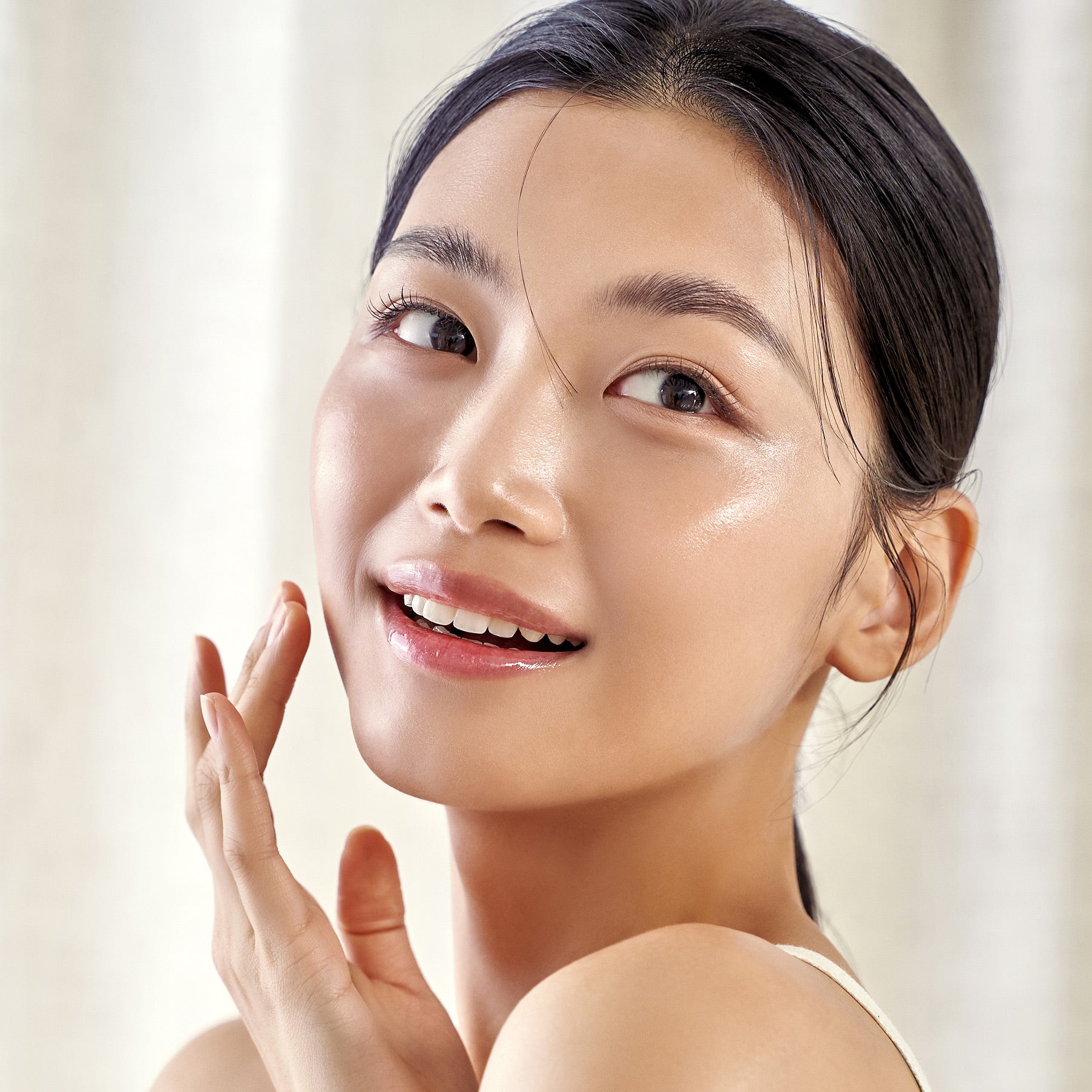 Décris en français : visage radieux utilisant PURITO Wonder Releaf Centella Daily Sun Lotion SPF50+PA++++, marque PURITO, contexte soin visage