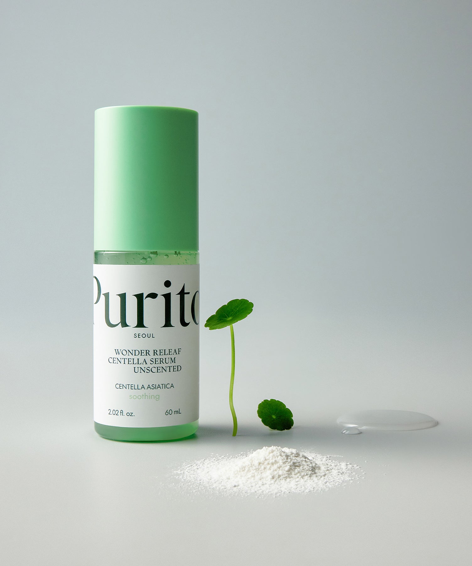 PURITO Wonder Releaf Centella Serum Unscented 60ml, flacon vert et gouttes sur fond clair avec feuilles de centella.